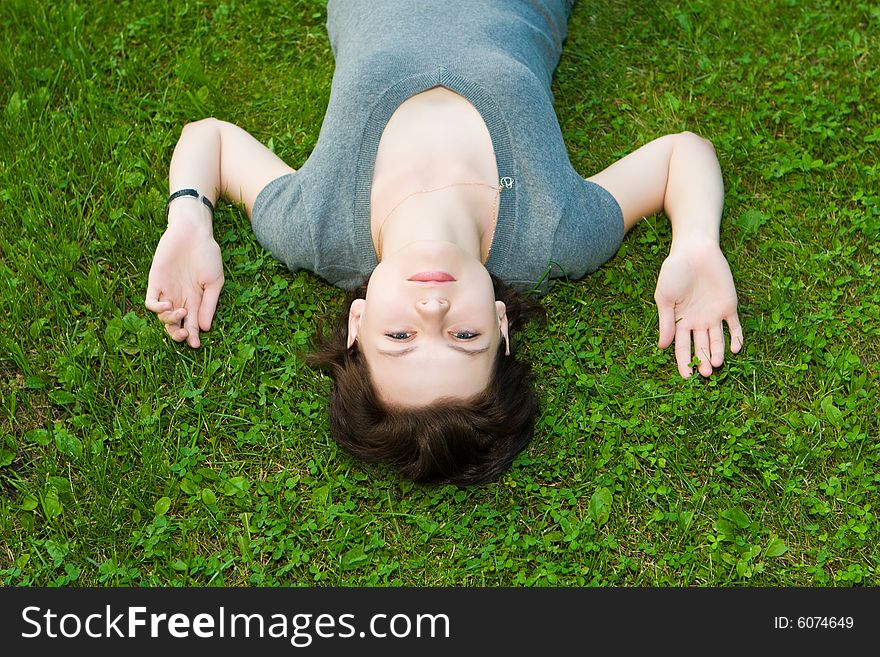Beautiful girl lays on a green grass. Beautiful girl lays on a green grass