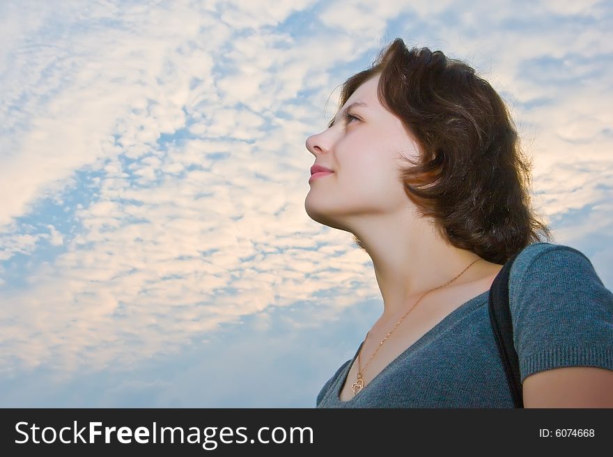 Portrait of the beautiful girl on a background of the blue sky with clouds. Portrait of the beautiful girl on a background of the blue sky with clouds