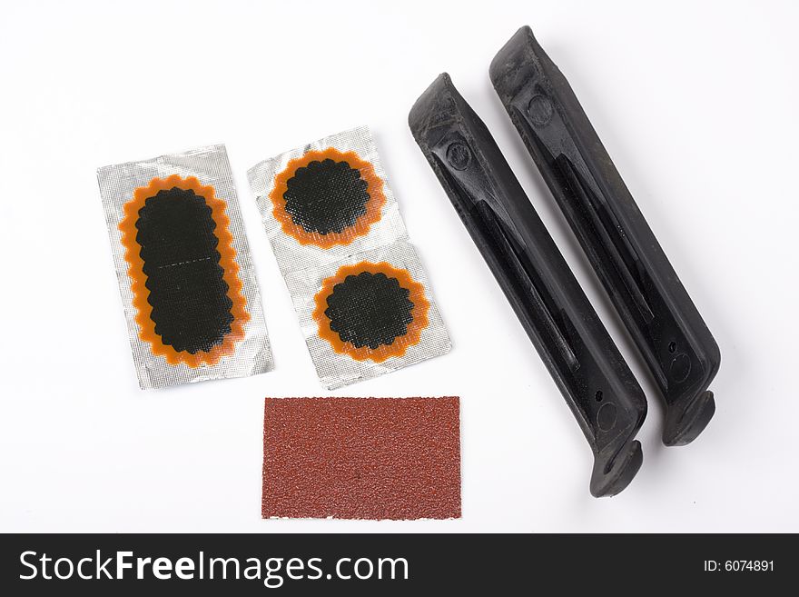 Bicycle repair patches and tools on white background