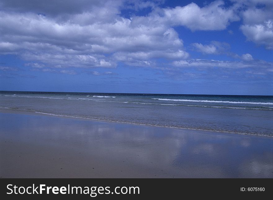 The blue sky,the clouds mirrored on the seaside. The blue sky,the clouds mirrored on the seaside..