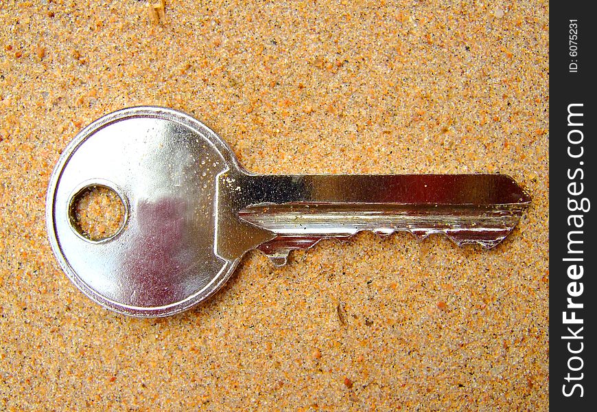 Photo of a key which lays on sand. Photo of a key which lays on sand.