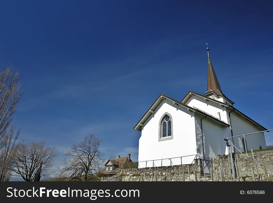 The church in the Swiss wine-growing village of Fechy. Space for copy in the clear blue sky. The church in the Swiss wine-growing village of Fechy. Space for copy in the clear blue sky.