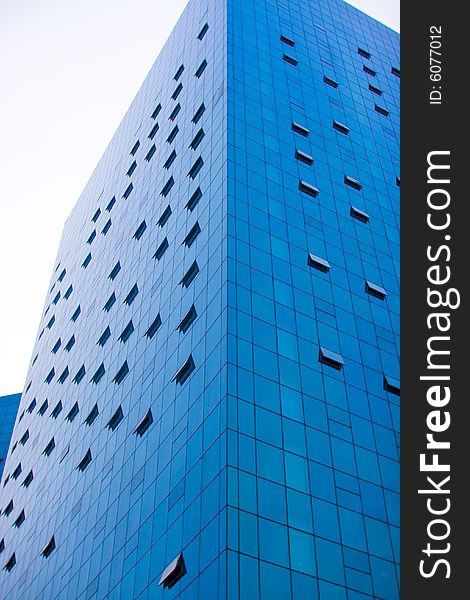 Modern skyscraper with blue windows, several of them being opened. Modern skyscraper with blue windows, several of them being opened.