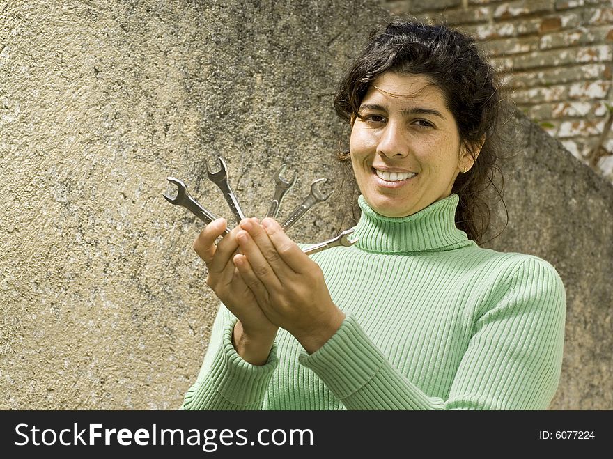 Smiling woman holding five wrenches. Vertically framed photo. Smiling woman holding five wrenches. Vertically framed photo.