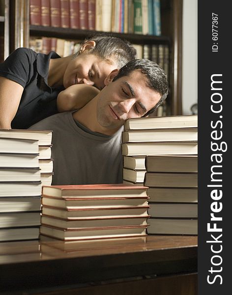 Young couple asleep on a pile of books. Vertically framed photograph. Young couple asleep on a pile of books. Vertically framed photograph.