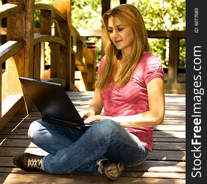 Beautiful young student using laptop outdoor. Beautiful young student using laptop outdoor.