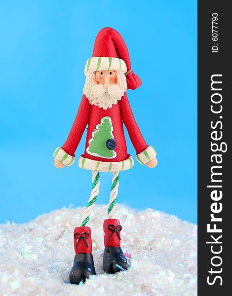 Slim santa claus christmas decoration on fake snow and blue background. Slim santa claus christmas decoration on fake snow and blue background