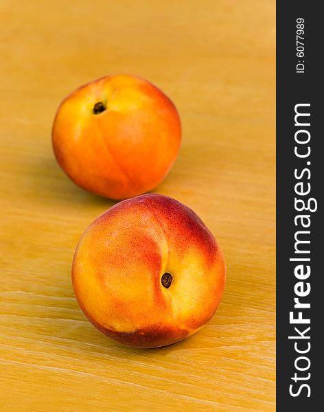 Two ripe nectarines on the wooden background