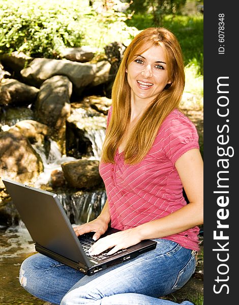 Beautiful young student using laptop in natural environment. Beautiful young student using laptop in natural environment.