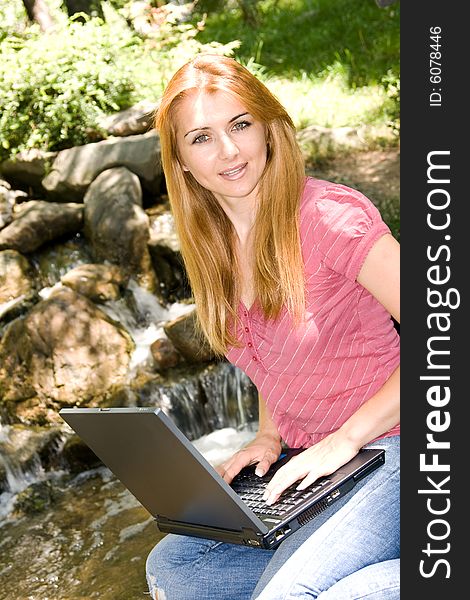 Beautiful young student using laptop in natural environment. Beautiful young student using laptop in natural environment.