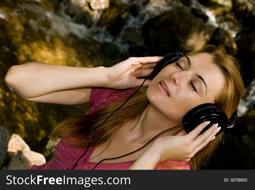 Music girl with headphones in natural environment.