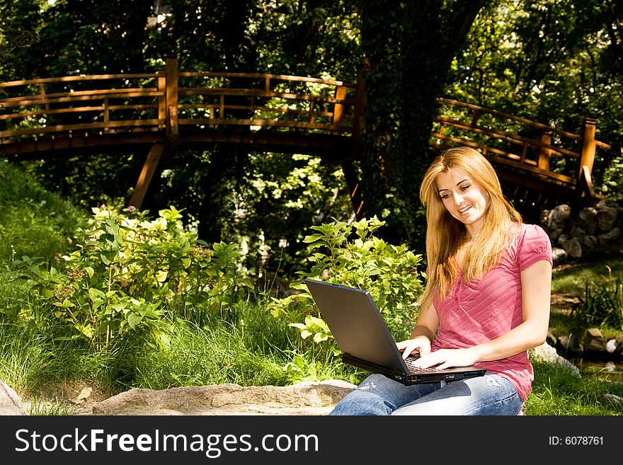 Beautiful young student using laptop in natural environment. Beautiful young student using laptop in natural environment.