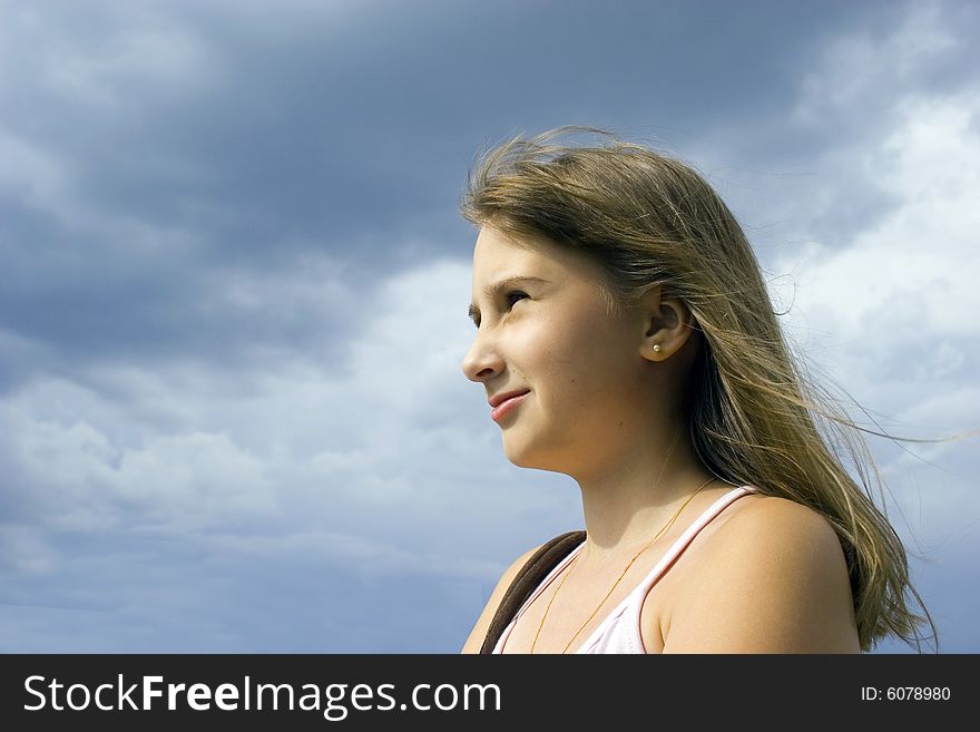 Young girl look forward on sky background