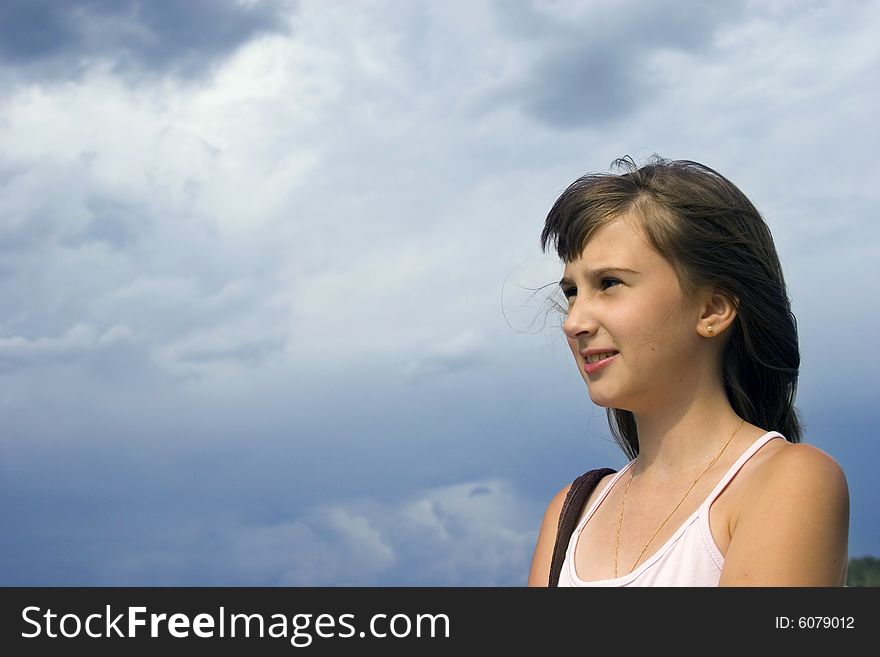 Young girl look forward on sky background