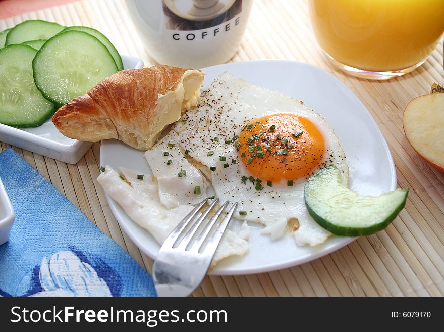 A healthy breakfast with eggs, bread, vegetables and juice