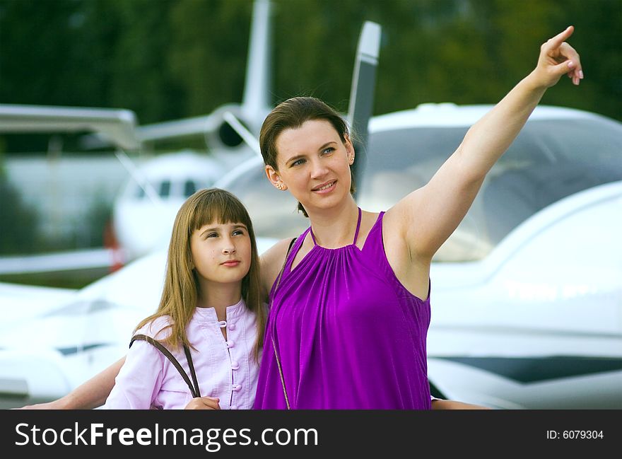 Mother looking daughter to airplane on front view. Mother looking daughter to airplane on front view.