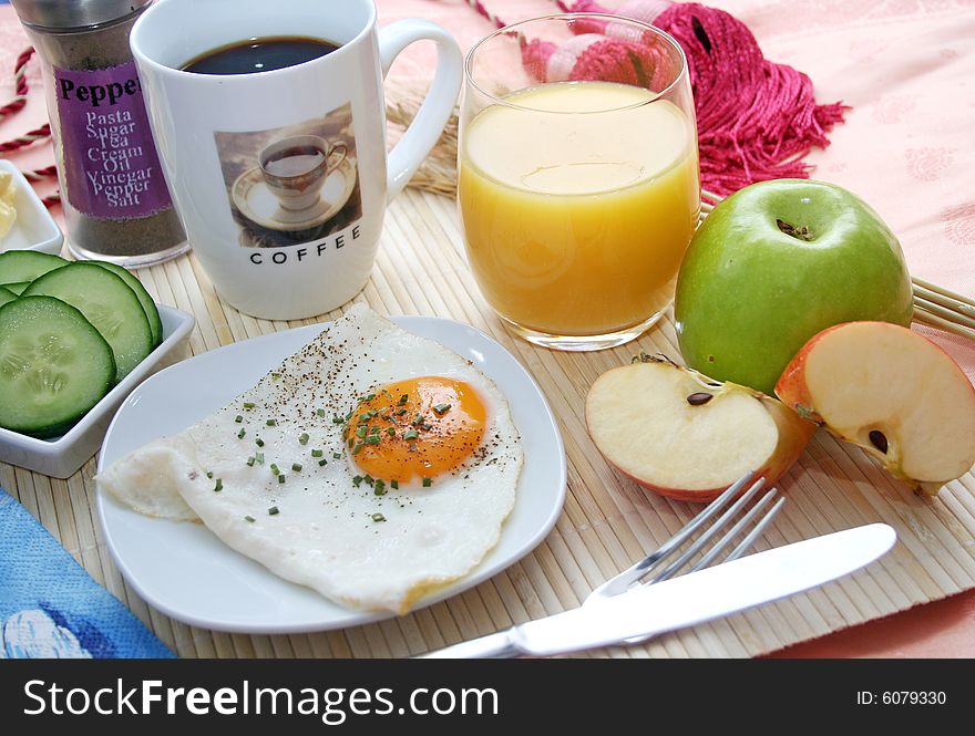A healthy breakfast with eggs, bread, vegetables and juice