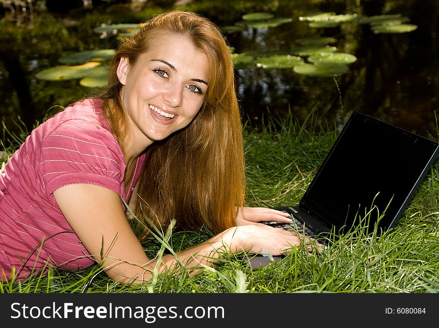 Beautiful young student using laptop in natural environment. Beautiful young student using laptop in natural environment.