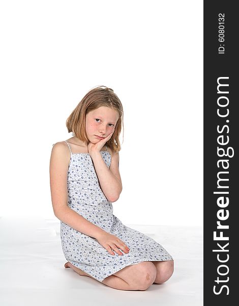 Pretty girl in dress kneeling and pouting. Pretty girl in dress kneeling and pouting