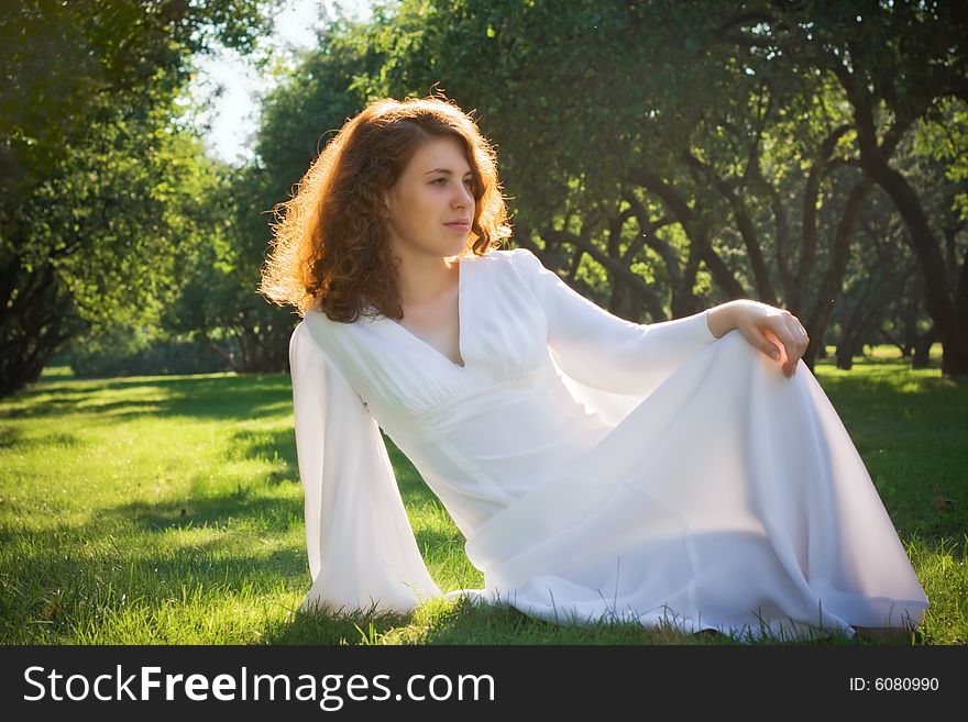 Young woman sit on meadow in garden. Young woman sit on meadow in garden