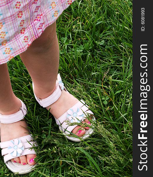 3 year old girlâ€™s feet, standing in the grass, in white dress sandals, with bright pink salon-pedicured toenails. 3 year old girlâ€™s feet, standing in the grass, in white dress sandals, with bright pink salon-pedicured toenails