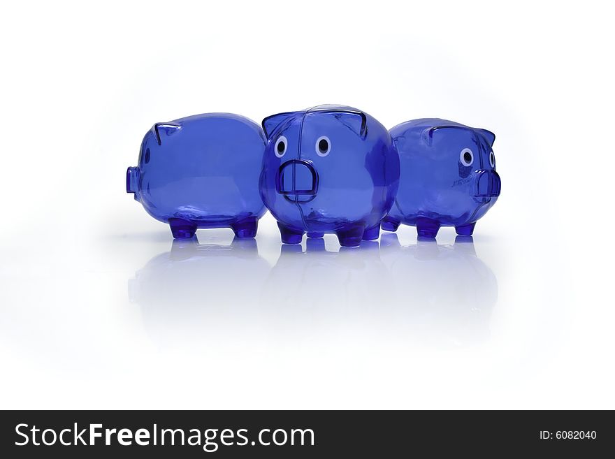 Three blue plastic piggy banks with a shadow and a reflection on a white seamless background. Three blue plastic piggy banks with a shadow and a reflection on a white seamless background.