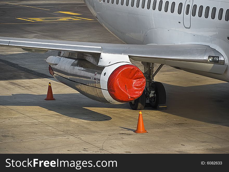 Parked & secured for the evening. This jet engine is carefully covered with a red plastic covering, as well as the orange witch hats, to assist in marking off the off limits zone, for pedestrian traffic. Parked & secured for the evening. This jet engine is carefully covered with a red plastic covering, as well as the orange witch hats, to assist in marking off the off limits zone, for pedestrian traffic.