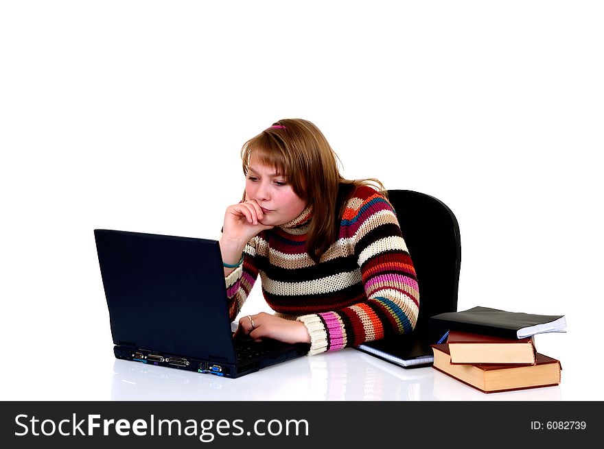 Teenager student doing homework with laptop and books on desk, with background, reflective surface