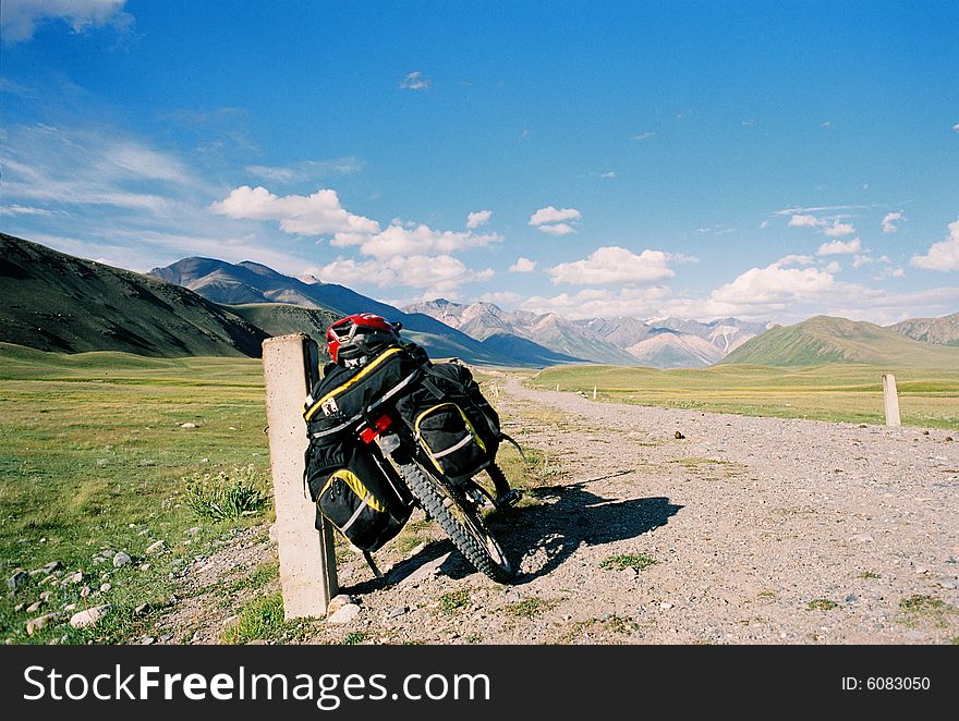 Bicycle on road on a background of mountains and the blue sky. Bicycle on road on a background of mountains and the blue sky