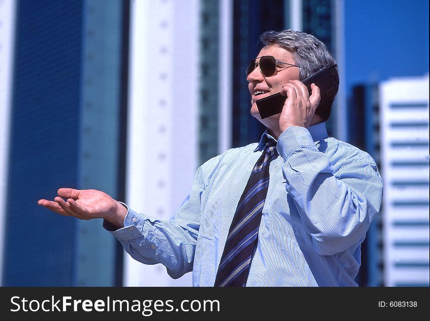 Manager using a cellphone in the center of a financial district