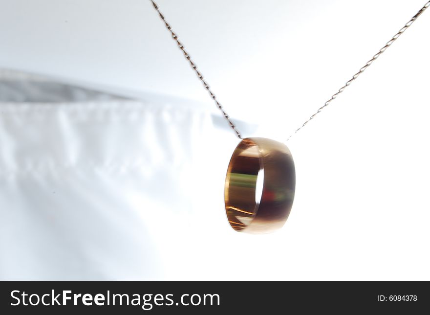 The wedding ring suspended on the shaken chain. The wedding ring suspended on the shaken chain.