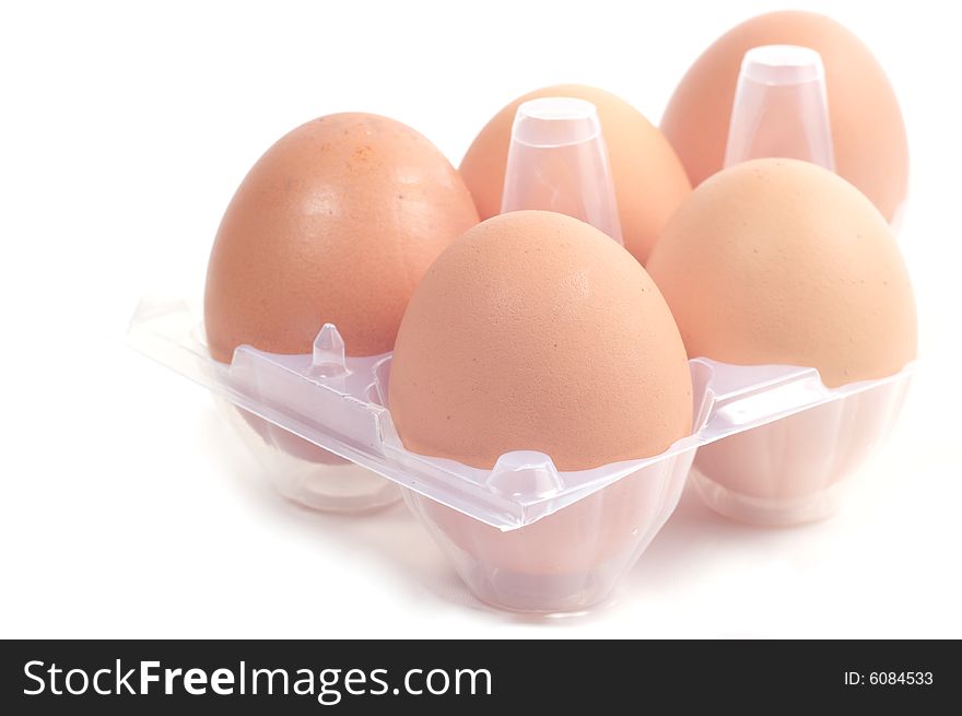 Five eggs in a plastic package. The color brown. Isolated on a white background. Five eggs in a plastic package. The color brown. Isolated on a white background.