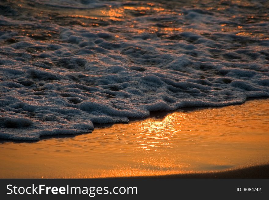 Sunset reflection on the sand with sea foam taken in lebanon near byblos