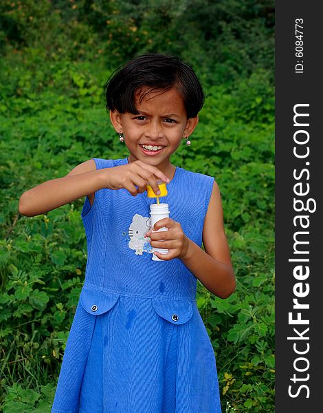 A small girl opening the lid of a bubble-maker.