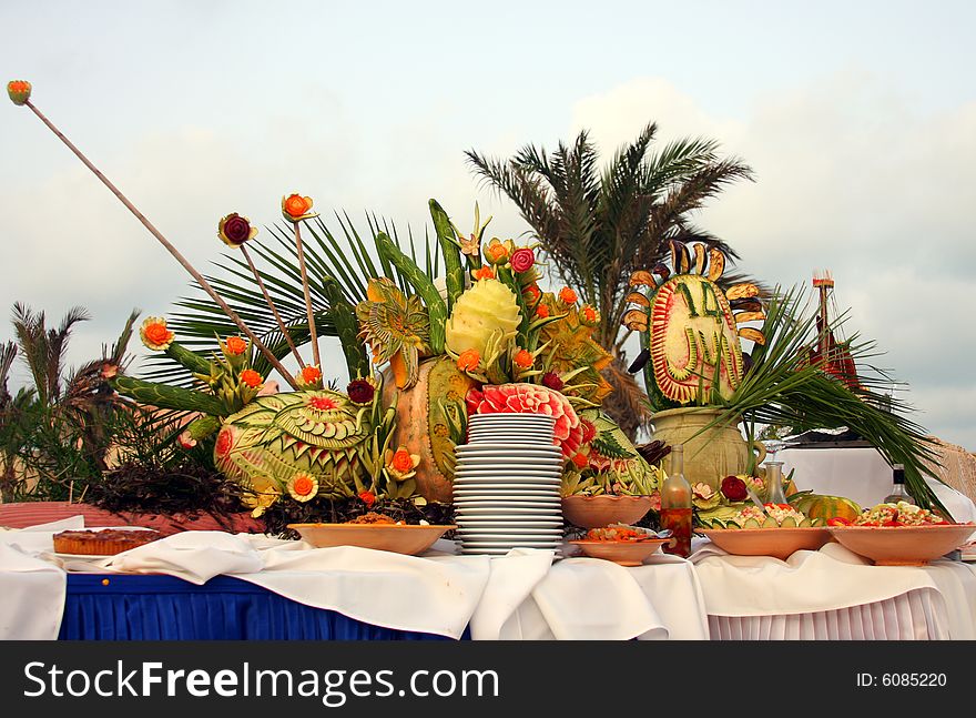 Setup of tropical food and fruits by the pool.
