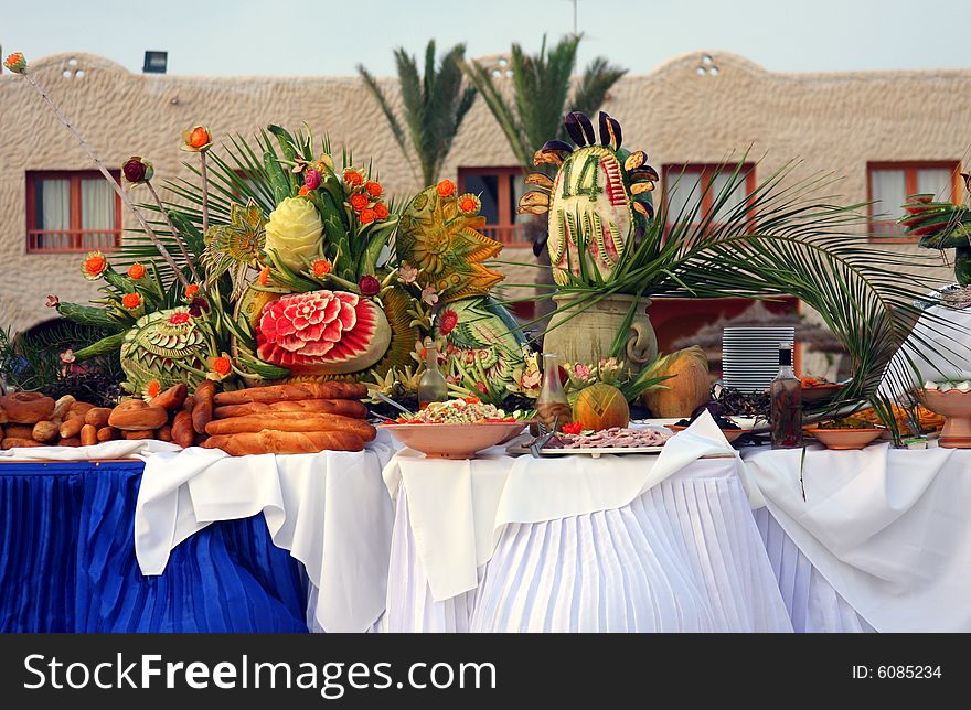 Setup of tropical food and fruits by the pool.