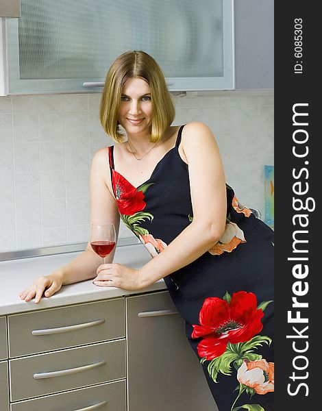 Young woman on kitchen witn a red wine