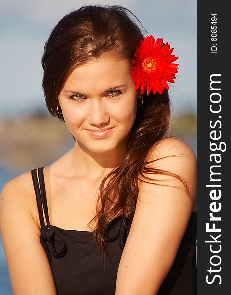 Young brunette girl with daisy in her hair. Young brunette girl with daisy in her hair