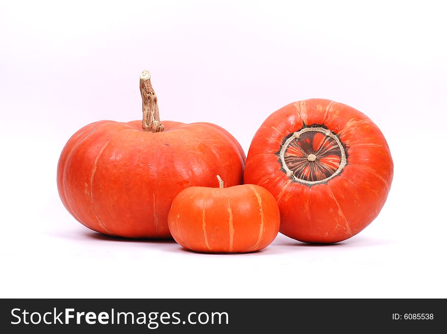 Three red pumpkins on white background.