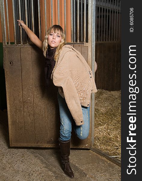 Fashion cow girl in a horse stable