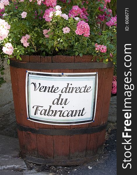 Large barrel filled with pink flowers with the words 'vente directe du fabricant' (direct sales) written on the side