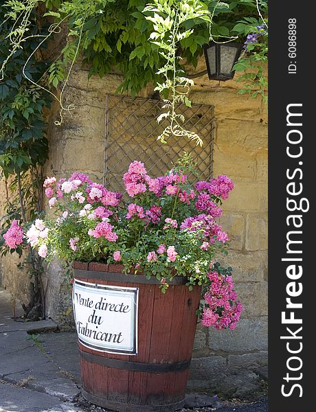 Large barrel filled with pink flowers with the words 'vente directe du fabricant' (direct sales) written on the side