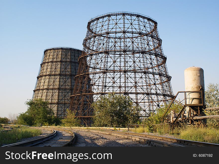 Cooling towers pipe-bridge and railways against blue sky. Cooling towers pipe-bridge and railways against blue sky