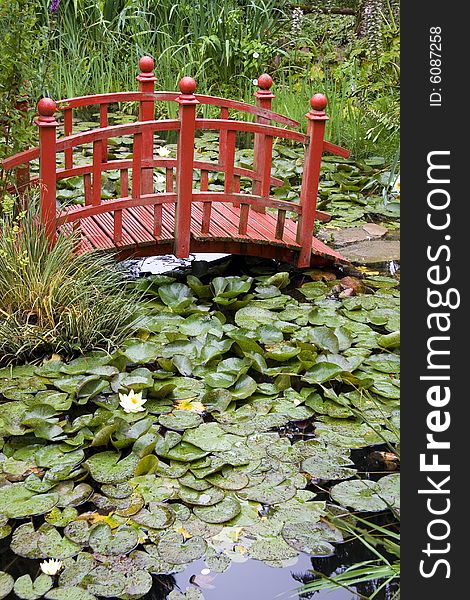 Japanese red ornamental bridge crossing a lake. Japanese red ornamental bridge crossing a lake