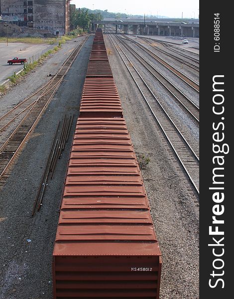 A row of freight cars seems to stretch into infinity as the cars sit in an industrial railway yard in Tennessee on a warm, summer day. A row of freight cars seems to stretch into infinity as the cars sit in an industrial railway yard in Tennessee on a warm, summer day.