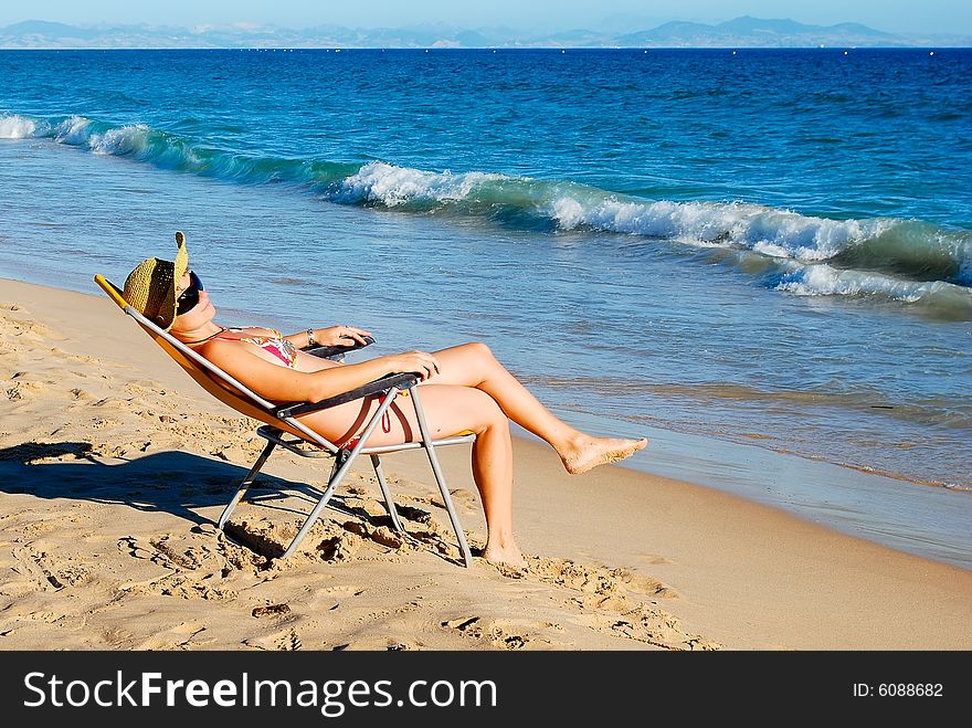 Young beautiful woman has a rest on coast of ocean