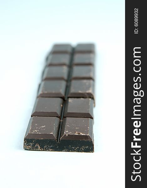 Dark chocolate isolated against a blue background