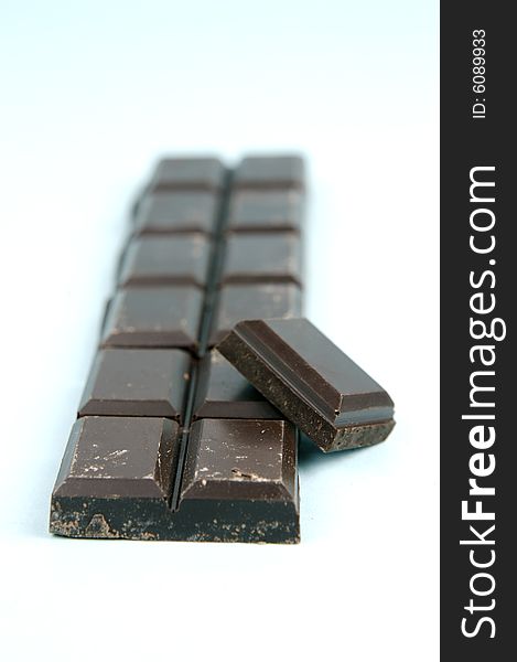 Dark chocolate isolated against a blue background