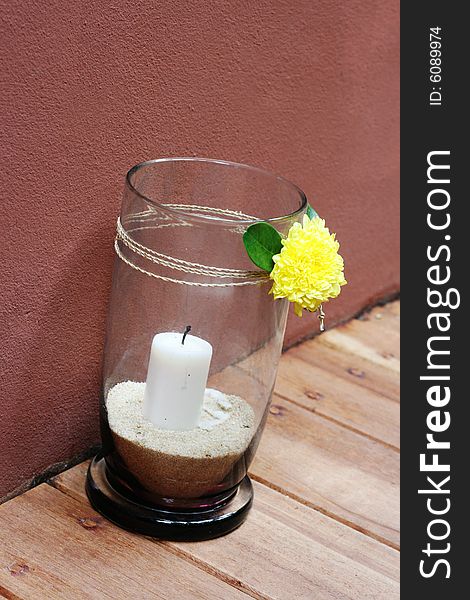 White candle in a vase with sand.