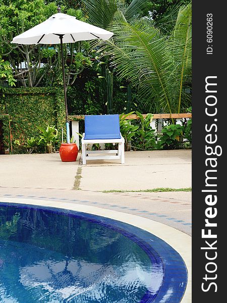 Deck chairs and umbrellas next to a swimming pool.